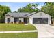 Charming single-story home with a well-maintained lawn, gray roof, and an attached two-car garage at 12929 Louisiana Woods Ct, Orlando, FL 32824