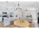 Open-concept kitchen and living area with modern lighting, stainless appliances, and a breakfast bar at 12929 Louisiana Woods Ct, Orlando, FL 32824