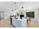 Bright open-concept kitchen and living area with modern lighting, stainless appliances, fireplace and a breakfast bar at 12929 Louisiana Woods Ct, Orlando, FL 32824