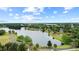 The aerial view showcases a lake, walkways, lush trees, and the surrounding neighborhood at 12952 Downstream Cir, Orlando, FL 32828