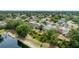 Neighborhood houses seen from above with a lush green canopy of trees and a pond nearby at 12952 Downstream Cir, Orlando, FL 32828