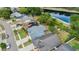 An aerial view showcases the neighborhood with houses, solar panels, streets, and a pond nearby at 12952 Downstream Cir, Orlando, FL 32828