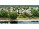 This aerial shot shows neighborhood houses with lush green trees and a pond in the distance at 12952 Downstream Cir, Orlando, FL 32828