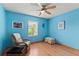 Bright bedroom features a ceiling fan, wood floors, and a cozy seating area near the window at 12952 Downstream Cir, Orlando, FL 32828