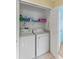 Convenient laundry closet equipped with a washer, dryer, and shelving for organized storage at 12952 Downstream Cir, Orlando, FL 32828