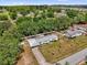 Aerial view of property surrounded by green trees in a residential area at 13009 Plum Lake Cir, Minneola, FL 34715