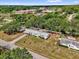 Aerial view of the home showing surrounding greenery and community buildings at 13009 Plum Lake Cir, Minneola, FL 34715