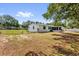 Backyard with chain link fence, green grass, shade trees and white home at 13009 Plum Lake Cir, Minneola, FL 34715