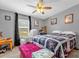 Cozy bedroom with a large window, chair, and bed with floral-patterned quilt at 13009 Plum Lake Cir, Minneola, FL 34715