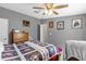 Bedroom with ceiling fan, art on the walls, and a colorful floral bedspread at 13009 Plum Lake Cir, Minneola, FL 34715
