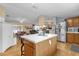 Open kitchen with island, stainless steel appliances, view of dining & living areas at 13009 Plum Lake Cir, Minneola, FL 34715