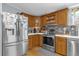 Traditional kitchen with stainless steel appliances, wooden cabinets, and light countertops at 13009 Plum Lake Cir, Minneola, FL 34715