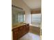 Bathroom with double vanity, large mirror, window, and soaking tub at 13543 Emeraldview Dr, Orlando, FL 32828