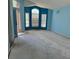 Light blue vacant living room with large windows and view to the front yard at 13543 Emeraldview Dr, Orlando, FL 32828