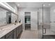 Bathroom with a walk-in shower, dual sinks, and neutral colors at 14138 Alafaya Oak Bnd, Orlando, FL 32828