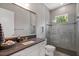 A clean bathroom featuring a gray color palette with a glass enclosed shower, toilet and sink at 14138 Alafaya Oak Bnd, Orlando, FL 32828