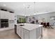 Spacious kitchen and dining area with white cabinets, an island, and stainless steel appliances at 14138 Alafaya Oak Bnd, Orlando, FL 32828