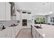 Modern island kitchen featuring white cabinets, stainless steel appliances, and backyard view at 14138 Alafaya Oak Bnd, Orlando, FL 32828