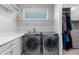 Bright laundry room featuring modern washer and dryer units and ample shelving for storage at 14138 Alafaya Oak Bnd, Orlando, FL 32828