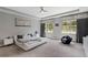 Main bedroom featuring a modern bed, tray ceiling, and large windows at 14138 Alafaya Oak Bnd, Orlando, FL 32828