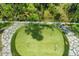 Aerial view of backyard putting green surrounded by stone at 14138 Alafaya Oak Bnd, Orlando, FL 32828