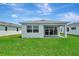 Rear exterior view showing patio and green lawn at 1459 Santorini Way, Tavares, FL 32778