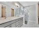 Modern bathroom featuring double sink vanity, marble tile walls, and a glass-enclosed shower at 1459 Santorini Way, Tavares, FL 32778