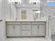 Bathroom featuring double sink vanity, marble floors, and a glass-enclosed shower at 1459 Santorini Way, Tavares, FL 32778