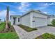 Charming single-story home features a well-manicured lawn, paved driveway, and attached two-car garage at 1459 Santorini Way, Tavares, FL 32778