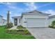 Charming single-story home features a well-manicured lawn, paved driveway, and attached two-car garage at 1459 Santorini Way, Tavares, FL 32778