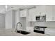 Bright kitchen features modern white cabinets, stainless appliances, granite counters, and a gray backsplash at 1459 Santorini Way, Tavares, FL 32778