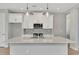 Modern kitchen features a gray backsplash, stainless appliances, and a large center island with sink at 1459 Santorini Way, Tavares, FL 32778