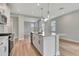 Bright kitchen features modern white cabinets, stainless appliances, granite counters, and an island with a sink at 1459 Santorini Way, Tavares, FL 32778