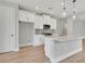 Bright kitchen features modern white cabinets, stainless appliances, granite counters, and an island with a sink at 1459 Santorini Way, Tavares, FL 32778