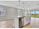 Open-concept kitchen features a center island with sink and seating, stainless appliances, and a view to the backyard at 1459 Santorini Way, Tavares, FL 32778