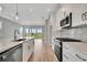 Bright kitchen features white cabinets, stainless appliances, granite counters, and an island with a sink at 1459 Santorini Way, Tavares, FL 32778