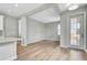 Bright open floor plan with kitchen island, light wood floors, and a glass pane front door at 1459 Santorini Way, Tavares, FL 32778