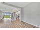 Open floor plan featuring wood floors, large sliding glass doors, and kitchen with white cabinets at 1459 Santorini Way, Tavares, FL 32778
