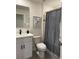 Cozy bathroom features a white vanity with modern black fixtures and a shower with a stylish curtain at 1832 Katz Crossing Dr, Kissimmee, FL 34744