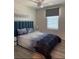 Comfortable bedroom with a blue upholstered bed, a white nightstand and soft, natural light at 1832 Katz Crossing Dr, Kissimmee, FL 34744