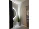Modern entryway featuring a round, illuminated mirror and decorative greenery in a white pot at 1832 Katz Crossing Dr, Kissimmee, FL 34744
