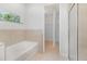 Clean bathroom featuring a bathtub and shower with neutral-tone tile and access to a walk-in closet at 196 Morning Glory Dr, Lake Mary, FL 32746