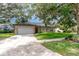 Inviting single-story home featuring a spacious driveway, two-car garage, and lush green lawn with mature trees at 196 Morning Glory Dr, Lake Mary, FL 32746