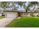 Charming single-story home features a well-maintained lawn, mature trees, and a two-car garage at 196 Morning Glory Dr, Lake Mary, FL 32746