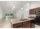 Open kitchen view featuring granite countertops, stainless steel sink, and access to the living room and pool area at 196 Morning Glory Dr, Lake Mary, FL 32746