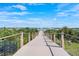 Scenic boardwalk view to the lake with community gazebo under a blue sky and white clouds at 2301 Datura Loop, St Cloud, FL 34772