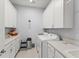 Spacious laundry room featuring a sink, counter, and white cabinets at 2301 Datura Loop, St Cloud, FL 34772