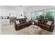 Open-concept living area with comfortable seating, stainless steel refrigerator and view of outdoor living space at 2301 Datura Loop, St Cloud, FL 34772