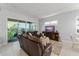 Comfortable living area with large brown sofas, ottoman, entertainment center and view of lanai at 2301 Datura Loop, St Cloud, FL 34772