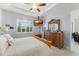 Cozy bedroom with ceiling fan, large window with plantation shutters, dresser, and comfortable bed at 2301 Datura Loop, St Cloud, FL 34772